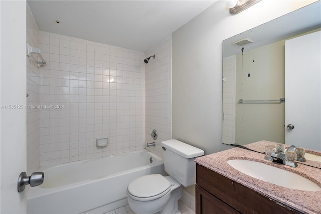 full bathroom with tiled shower / bath combo, tile floors, vanity, and toilet