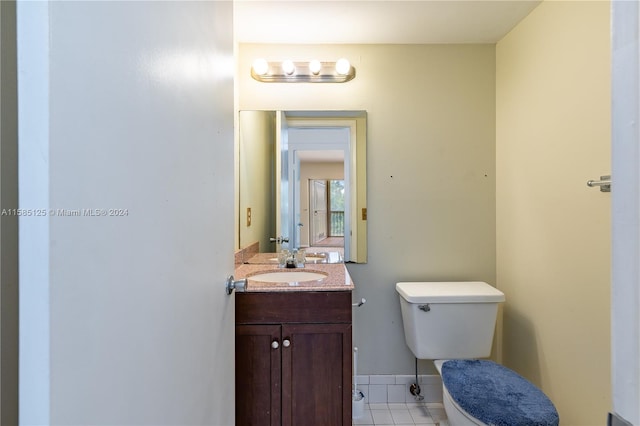 bathroom featuring large vanity, toilet, and tile flooring