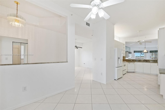 kitchen with ceiling fan with notable chandelier, hanging light fixtures, white appliances, and white cabinetry