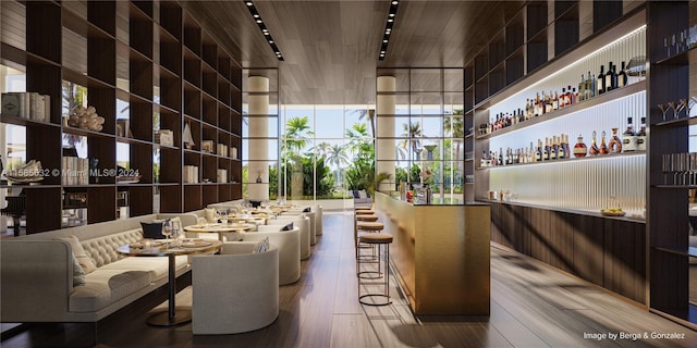 interior space with a wall of windows, track lighting, hardwood / wood-style flooring, and a towering ceiling