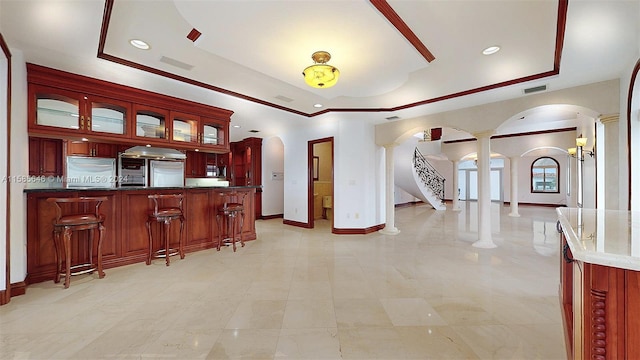 kitchen featuring light tile floors, a tray ceiling, decorative columns, and stainless steel built in refrigerator