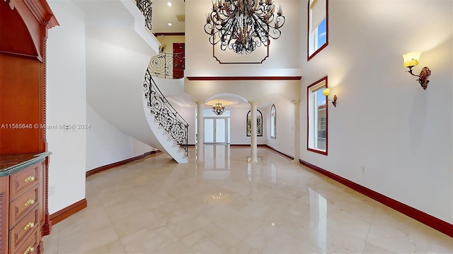 foyer featuring a wealth of natural light, a towering ceiling, and tile floors