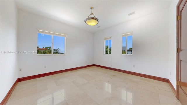 spare room with a healthy amount of sunlight and tile flooring