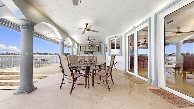 sunroom / solarium featuring ornate columns and ceiling fan