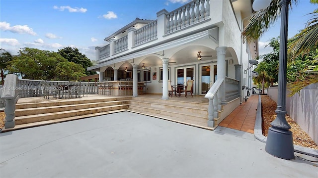 rear view of property featuring a balcony and a patio