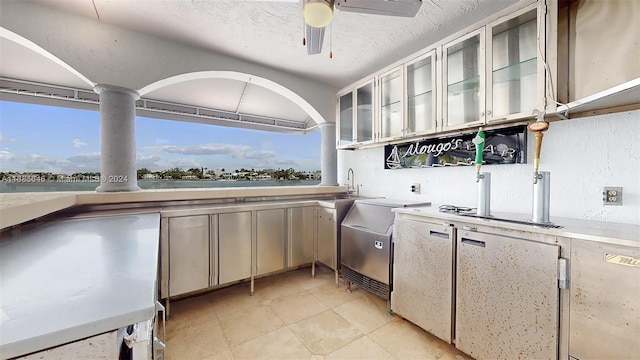 kitchen featuring ceiling fan and light tile floors