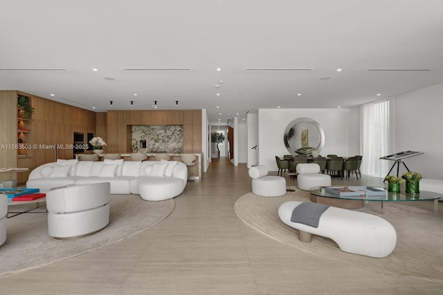 living room featuring wooden walls and light tile patterned flooring