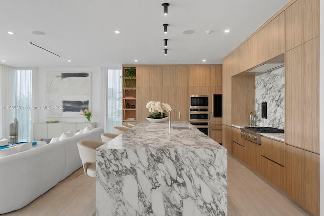 kitchen featuring plenty of natural light, sink, stainless steel appliances, and wooden walls