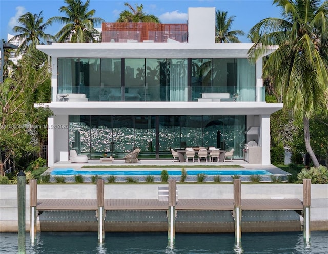 rear view of house featuring a patio area, a balcony, and a water view