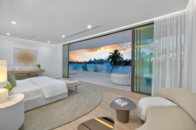 bedroom with access to outside, light hardwood / wood-style flooring, and a wall of windows