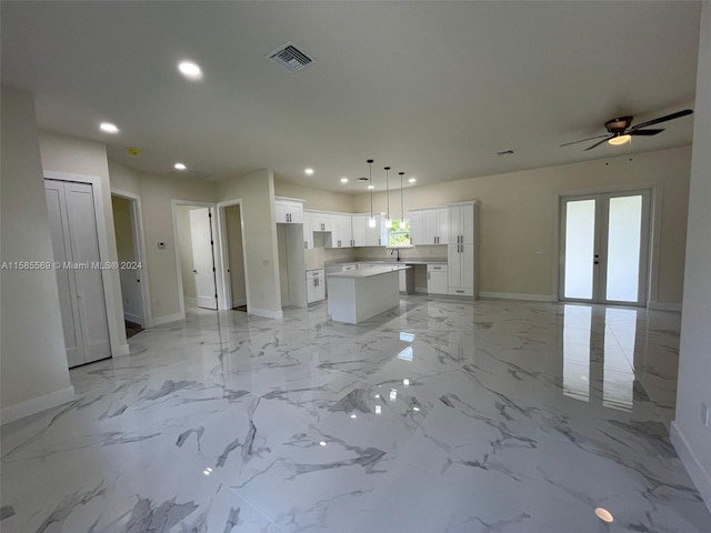 unfurnished living room with french doors, ceiling fan, sink, and light tile floors