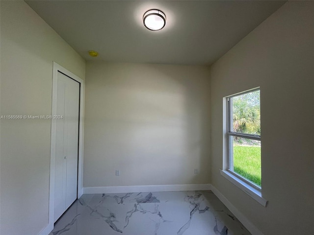 unfurnished bedroom with tile floors, a closet, and multiple windows