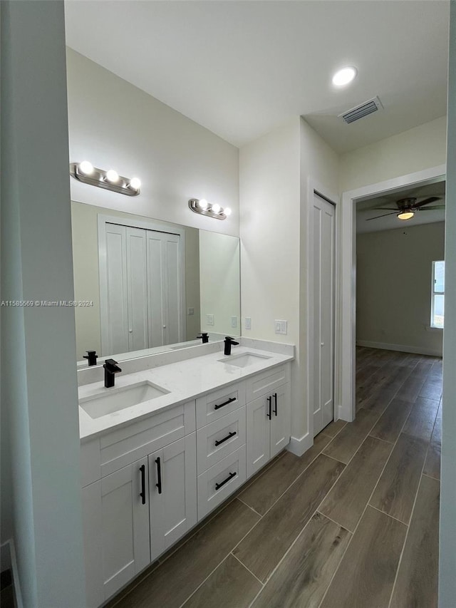 bathroom featuring hardwood / wood-style flooring, dual bowl vanity, and ceiling fan