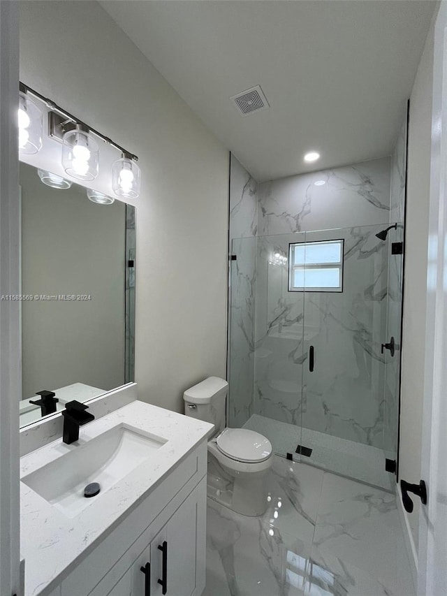 bathroom with vanity with extensive cabinet space, a shower with shower door, toilet, and tile flooring