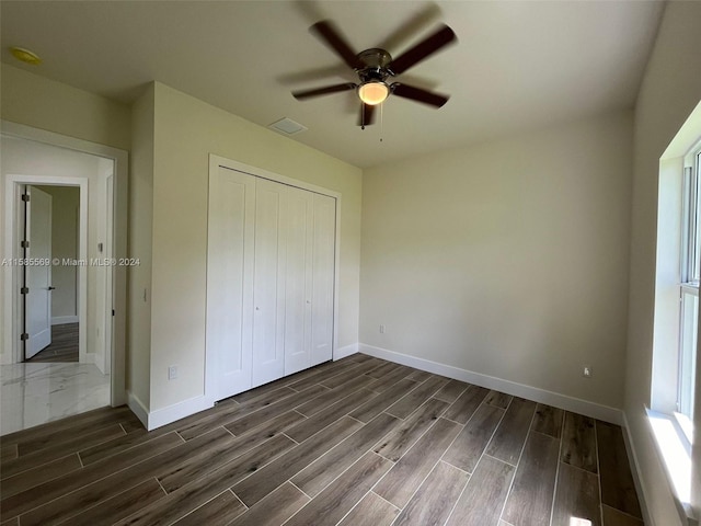 unfurnished bedroom featuring a closet, ceiling fan, and dark hardwood / wood-style flooring