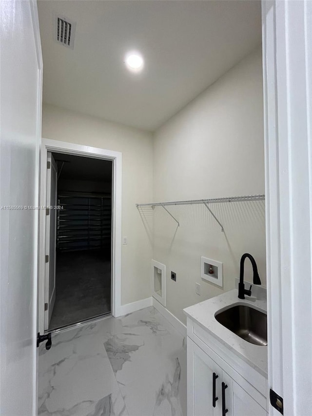 clothes washing area with hookup for an electric dryer, sink, and washer hookup