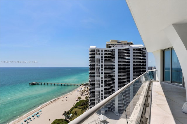 balcony with a beach view, a water view, and central AC