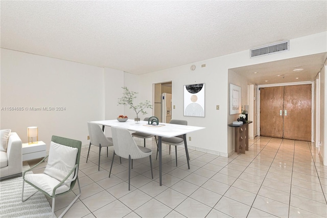 spare room featuring a textured ceiling and light tile patterned floors