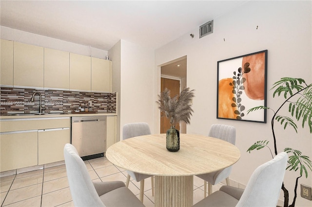 kitchen featuring appliances with stainless steel finishes, light tile patterned floors, backsplash, and cream cabinetry