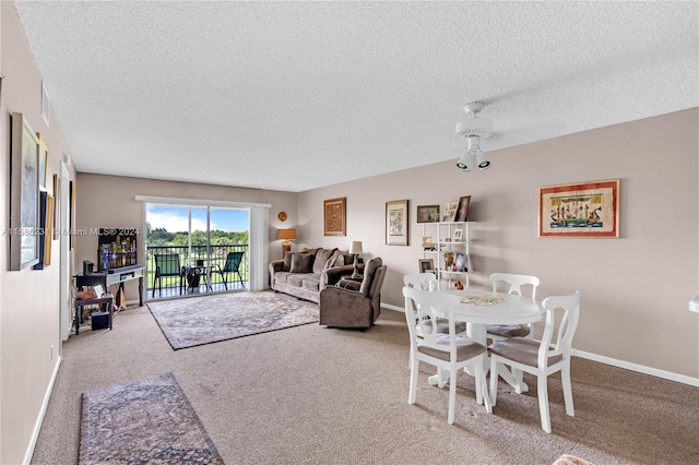 carpeted living room with ceiling fan and a textured ceiling