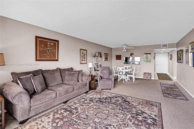 carpeted living room featuring a textured ceiling and ceiling fan