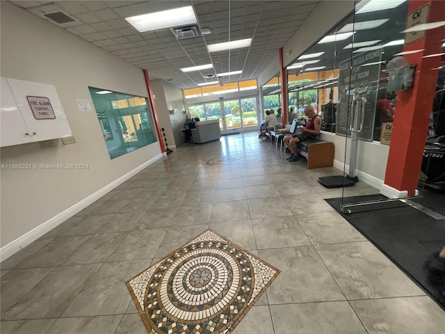 interior space with a drop ceiling and tile patterned flooring