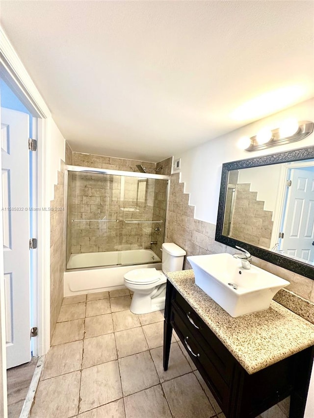 full bathroom featuring enclosed tub / shower combo, toilet, tile flooring, and vanity