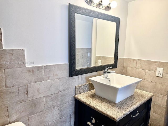 bathroom with vanity and tile walls