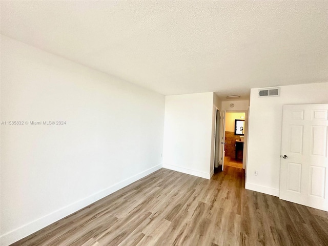 unfurnished bedroom featuring hardwood / wood-style flooring and a textured ceiling