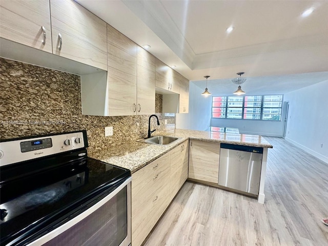 kitchen with sink, appliances with stainless steel finishes, kitchen peninsula, and light brown cabinets