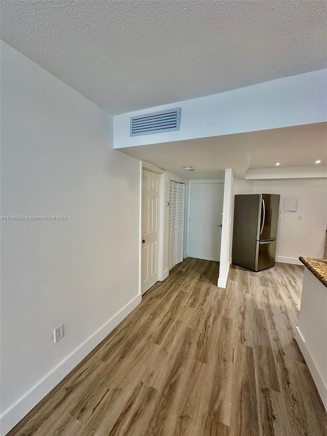 empty room featuring hardwood / wood-style flooring and a textured ceiling