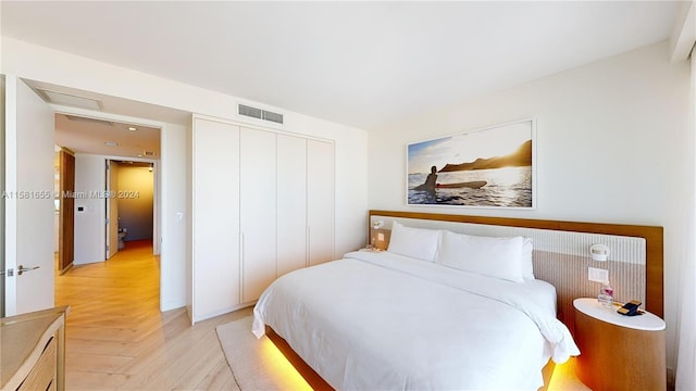 bedroom with light parquet floors and a closet