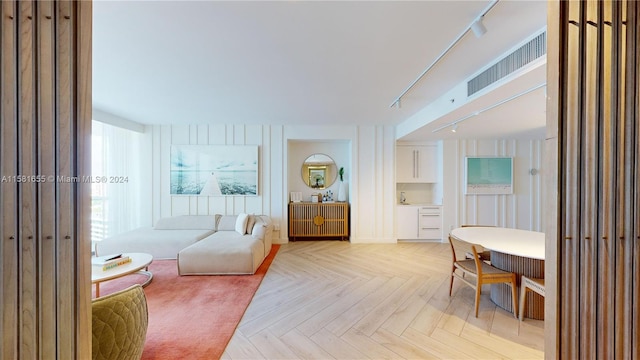 foyer with light parquet floors and rail lighting