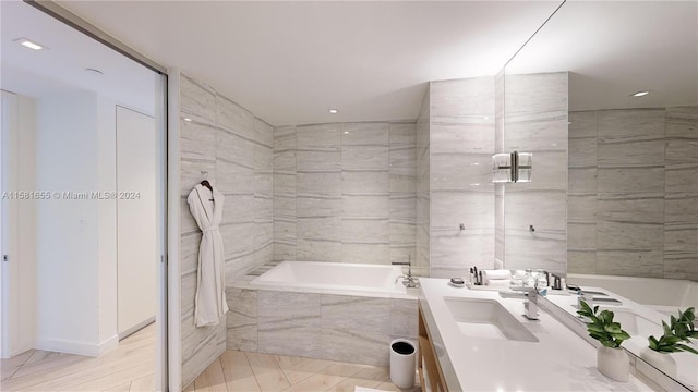 bathroom with tile flooring, tiled bath, and oversized vanity