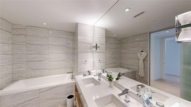 bathroom with tile flooring, double vanity, and tile walls