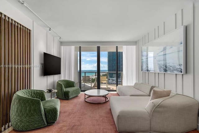 living room featuring a water view, expansive windows, and rail lighting