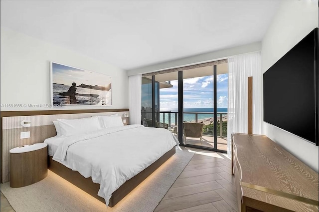 bedroom featuring a water view, parquet flooring, and access to outside