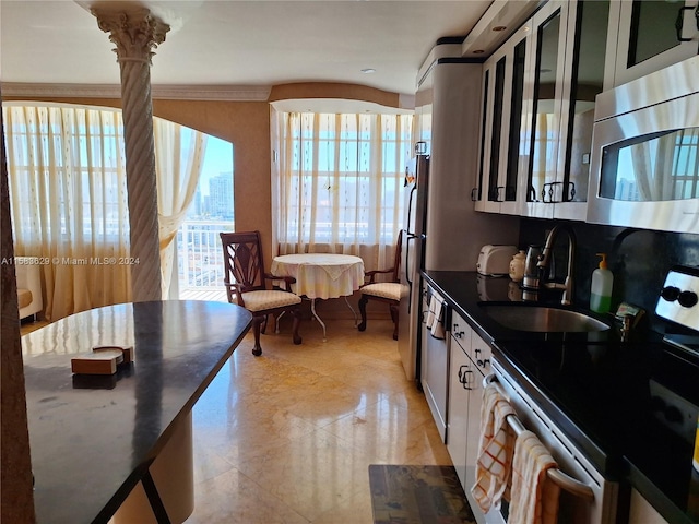 kitchen featuring white cabinetry, stainless steel appliances, sink, and ornate columns