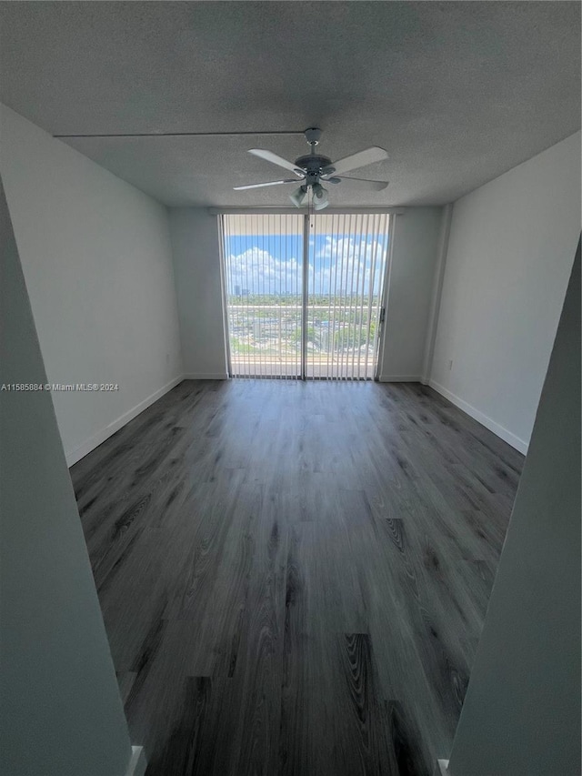 spare room with floor to ceiling windows, dark hardwood / wood-style floors, and a textured ceiling