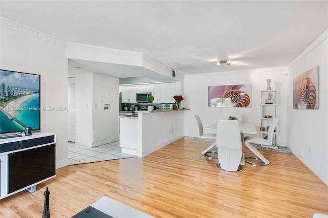 dining area featuring ornamental molding and light hardwood / wood-style floors