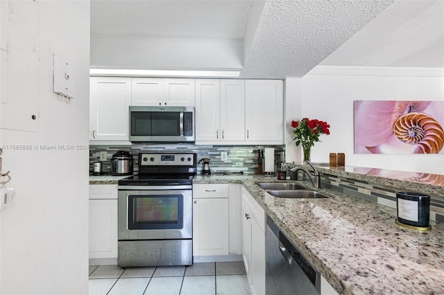 kitchen with sink, tasteful backsplash, a textured ceiling, white cabinetry, and appliances with stainless steel finishes