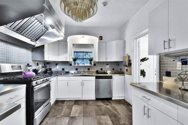 kitchen with tasteful backsplash, stainless steel appliances, stainless steel counters, wall chimney range hood, and white cabinetry