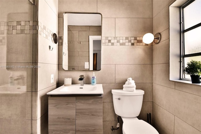 bathroom with vanity with extensive cabinet space, toilet, and tile walls