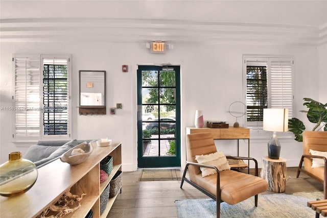 sitting room featuring beamed ceiling, a healthy amount of sunlight, and hardwood / wood-style floors