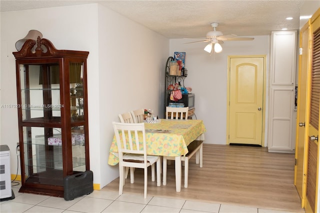 tiled dining room featuring ceiling fan and a textured ceiling