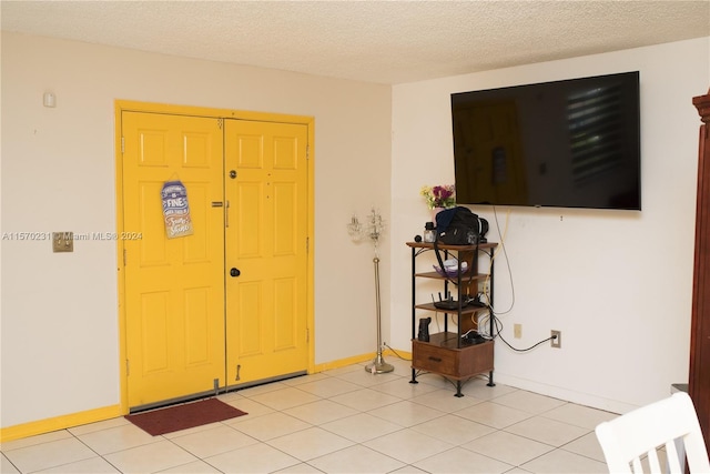 entryway with light tile patterned floors and a textured ceiling