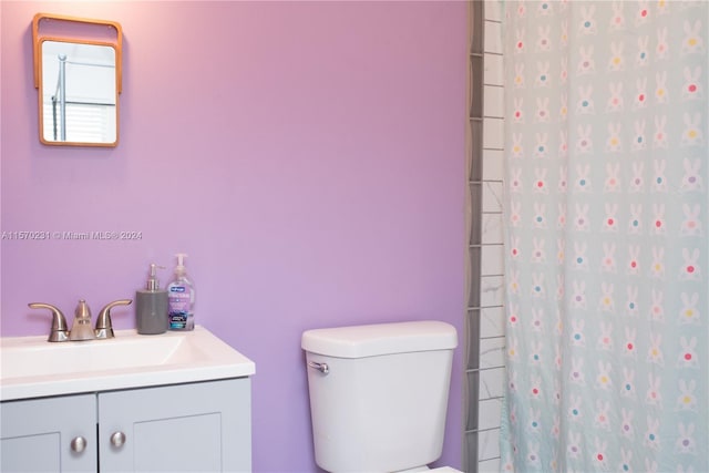 bathroom featuring a shower with curtain, vanity, and toilet