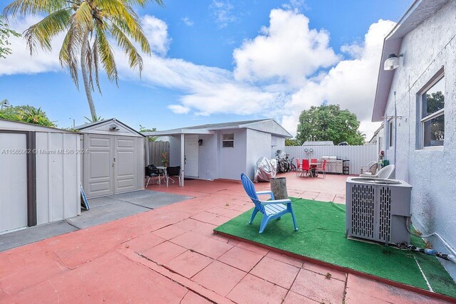 view of patio featuring a storage unit and central AC