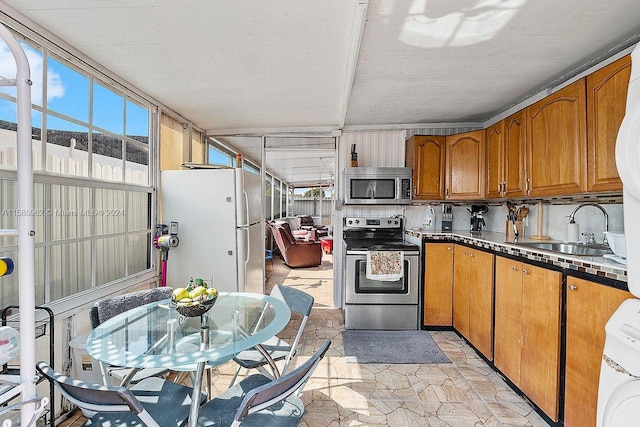 kitchen with stainless steel appliances, washer / clothes dryer, backsplash, and sink