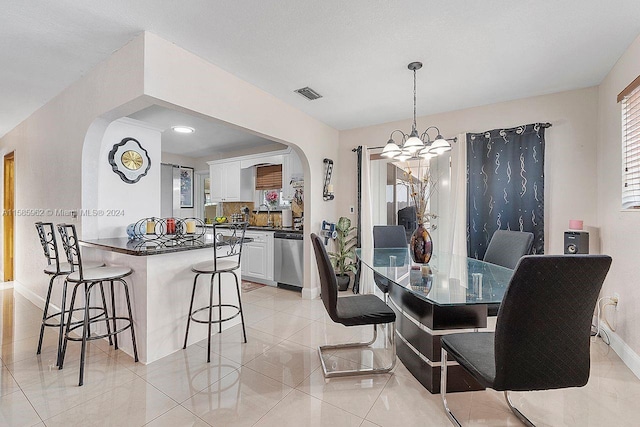 tiled dining area with sink and a chandelier